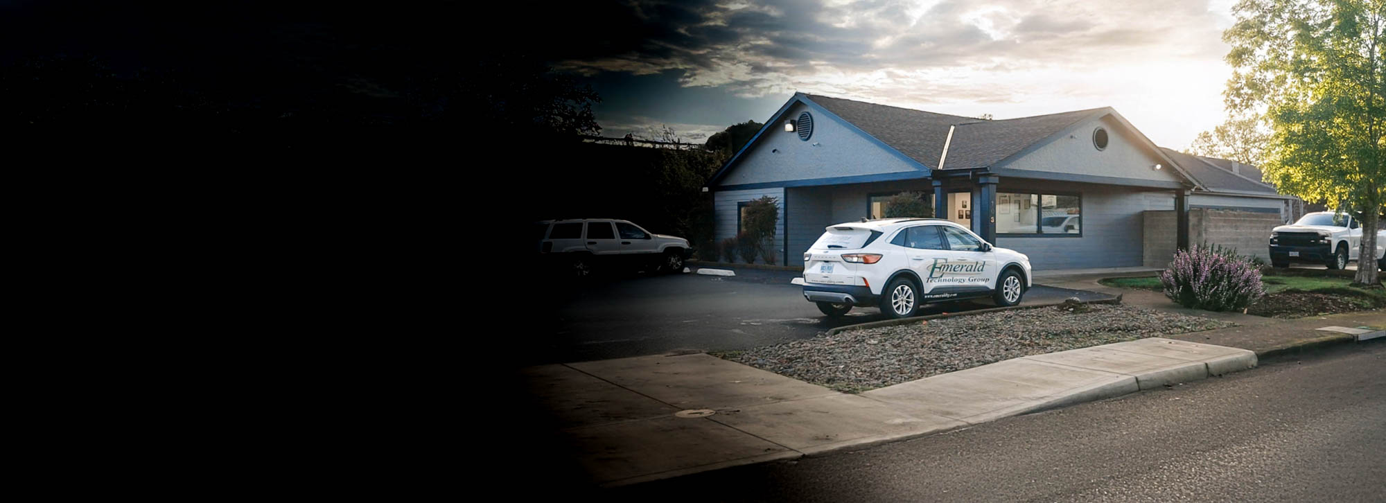 A white SUV parked near a blue building under a cloudy sky.